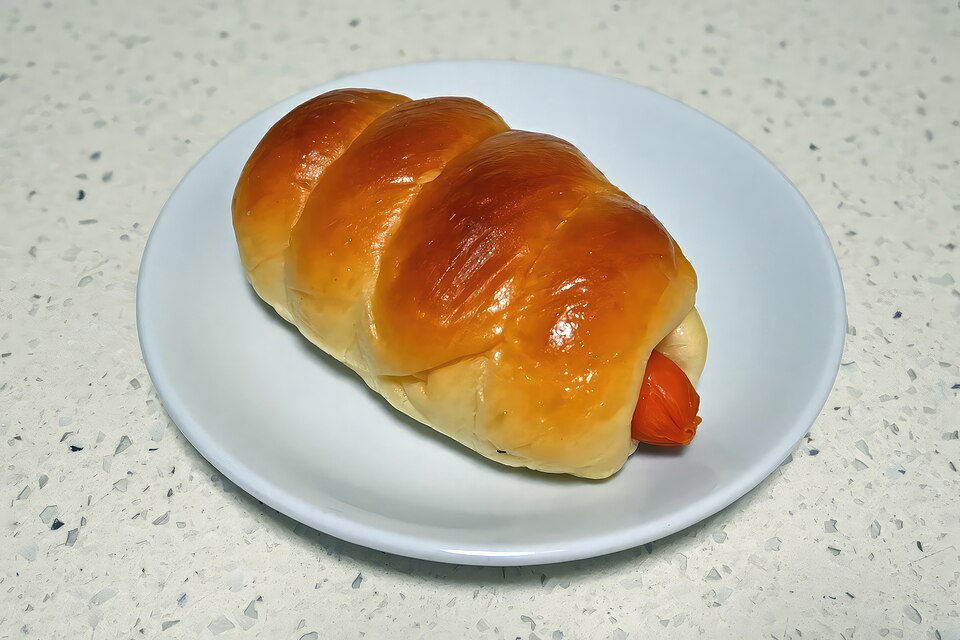 Soft baked bread wrapped around a sausage