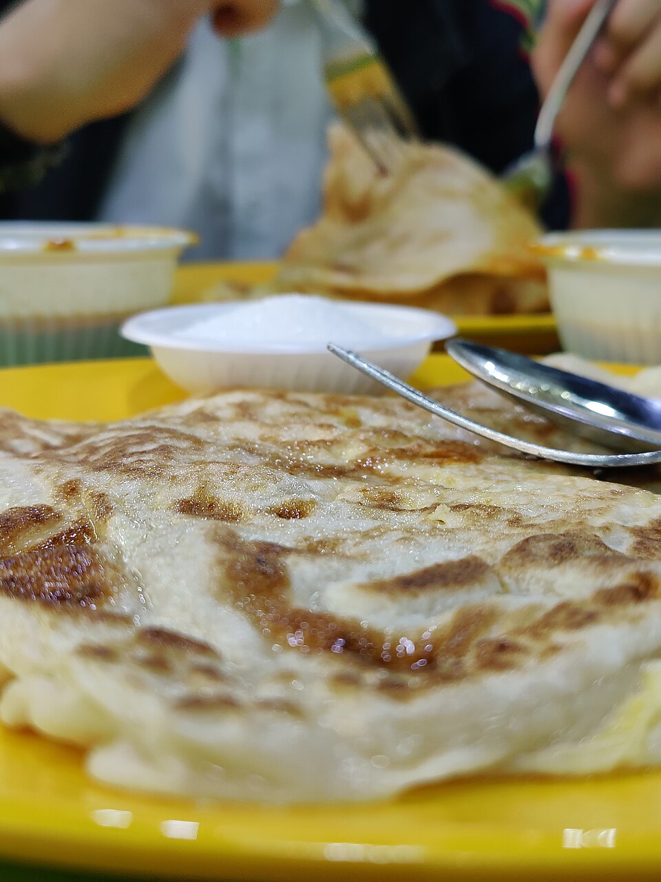 Pan-cooked roti prata served with curry